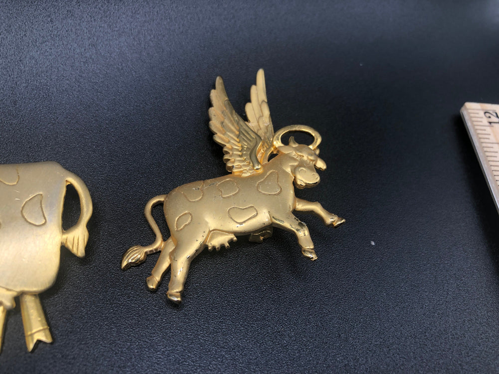 Cows cows cows! Cute cows goldtone Lot of 2 brooches One has articulated moving legs other is angel with wings + halo Designer JJ